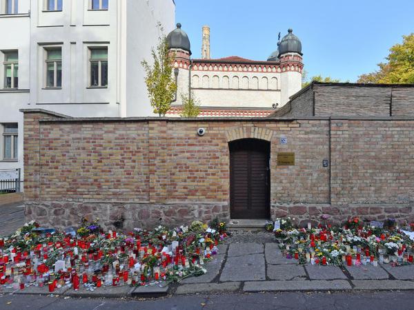 Blumen und Kerzen stehen im Oktober neben der Tür zur Synagoge in Halle, vier Tage nach dem rechtsextremistischen Anschlag auf die Gemeinde, bei dem der Täter zwei Passanten tötete. 