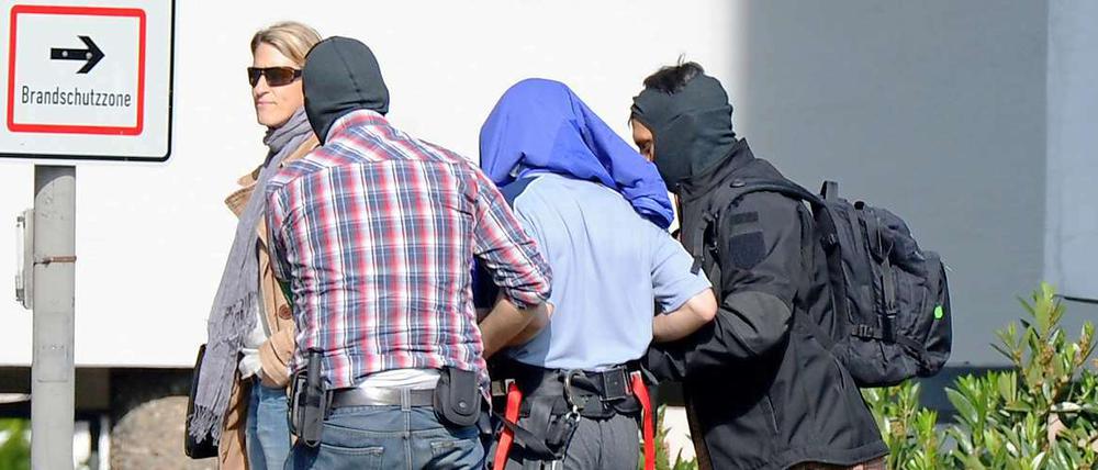 Einer der drei mutmaßlichen Terrorverdächtigen wird am Samstag auf dem Gelände des Bundesgerichtshofes in Karlsruhe aus einem Hubschrauber geführt.