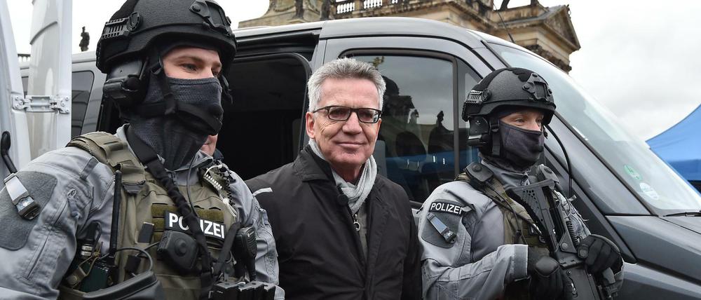 Bundesinnenminister Thomas de Maizière in Potsdam zwischen schwer bewaffneten Bundespolizisten.