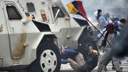 Ein Einsatzfahrzeug der Polizei fährt in Caracas einen Demonstranten um.