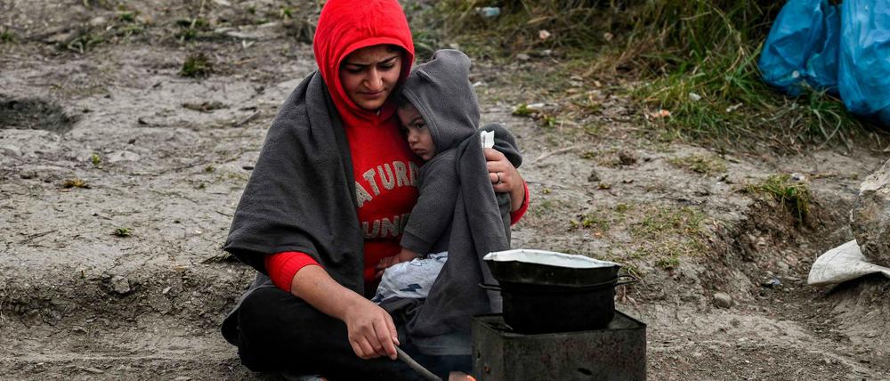 Eine Mutter und ihr Kind in einem improvisierten Lager beim Camp Moria auf Lesbos versuchen sich zu wärmen.