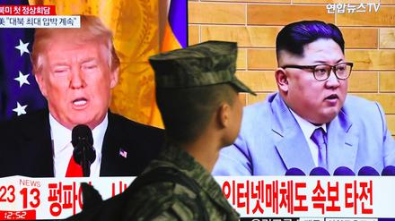 Ein südkoreanischer Soldat geht an einem Bildschirm vorbei auf dem US-Präsident Donald Trump und Nordkoreas Führer Kim Jong Un zu sehen sind. 