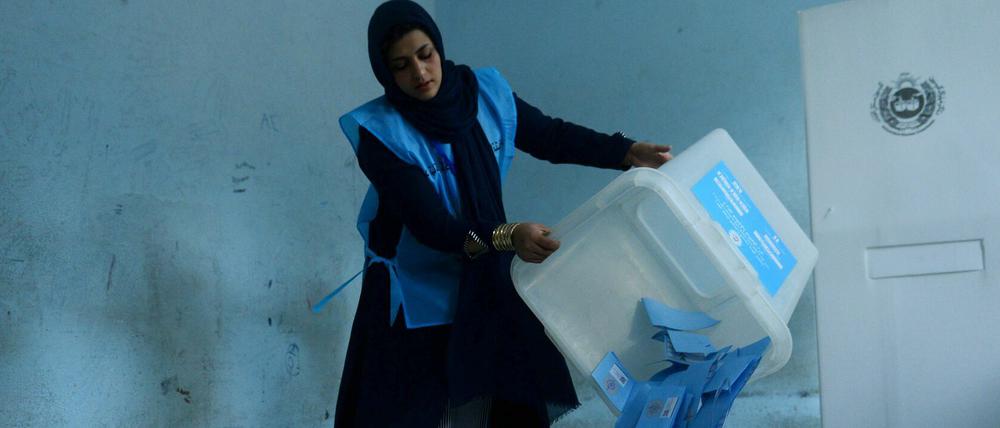 Eine Wahlhelferin in Herat leert eine Wahlurne.