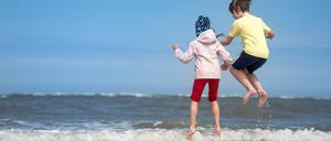 Zwei Kinder spielen am Strand in Ostfriesland. 