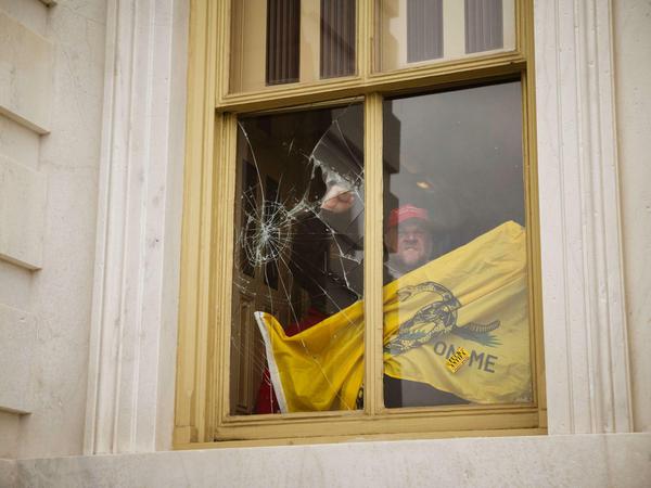 Ein Demonstrant zerbricht Scheiben im Kapitol.