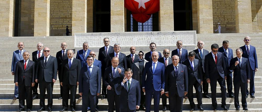 Der türkische Übergangspremier Ahmet Davutoglu posiert mit seinen frisch vereidigten Minister vor dem Atatürk-Mausoleum. Ayse Gürca, Mitte, ist die einzige Frau im Kabinett und die erste türkische Ministerin, die ein Kopftuch trägt.