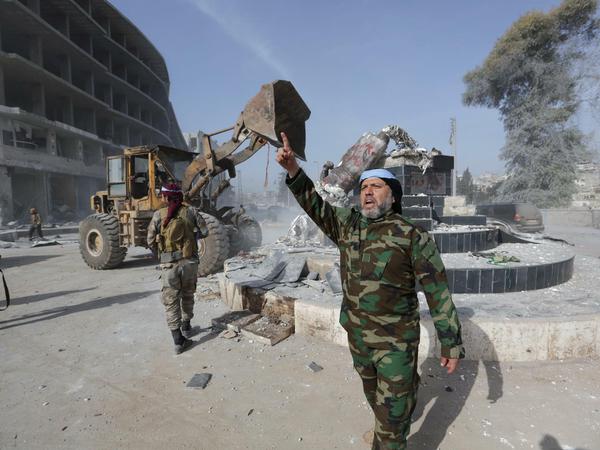 FSA-Kämpfer stürzen eine kurdische Statue im Zentrum von Afrin.