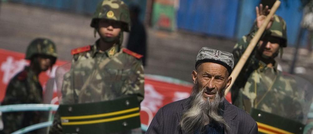 Unter Beobachtung: Ein Angehöriger der uigurischen Minderheit im Blick von chinesischen Sicherheitskräften (Archivbild)