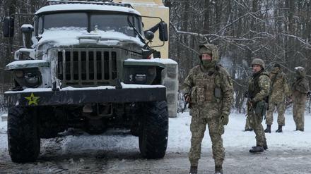 Ukrainische Soldaten stehen am Stadtrand von Charkiw.
