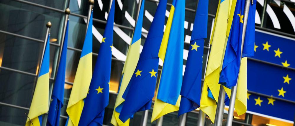 Die Flaggen der Ukraine und der Europäischen Union hängen zusammen an der Außenseite des Gebäudes vor einer außerordentlichen Plenarsitzung zum Ukraine-Konflikt im Europäischen Parlament am 1. März 2022