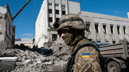 Ein ukrainischer Soldat bewacht ein durch Beschuss beschädigtes Gebäude in Charkiw. 