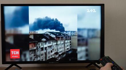 Auf einem Fernsehbildschirm läuft eine Nachrichtensendung über einen russischen Angriff.
