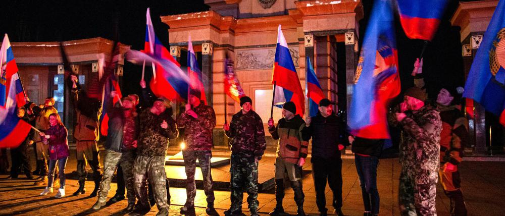 Dieses von der russischen Staatsagentur Tass verbreitete Bild zeigt Einwohner von Lugansk, die die Anerkennung der Unabhängigkeit der Volksrepubliken Donezk und Lugansk durch Russland feiern.