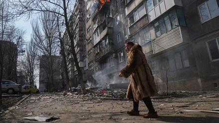 Eine Frau vor einem brennenden Wohnhaus in Mariupol