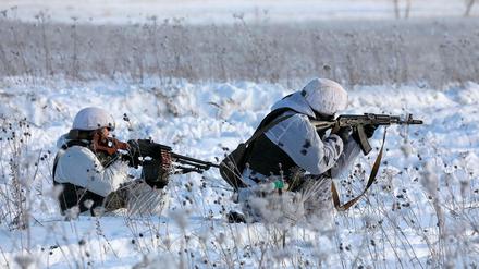 Zwei russische Soldaten, die ihre Schusswaffen während einer Militärübung ausrichten.