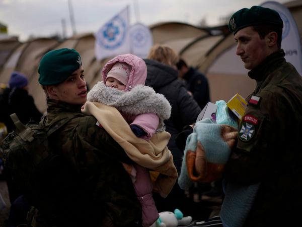 Die Massenflucht aus der Ukraine hält an. Polnische Soldaten mit einem Baby aus der Ukraine am Grenzübergang Medyka.