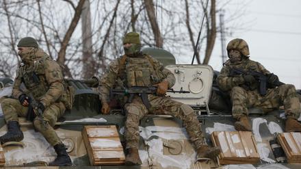 Russische Soldaten sitzen auf einem gepanzerten Fahrzeug.