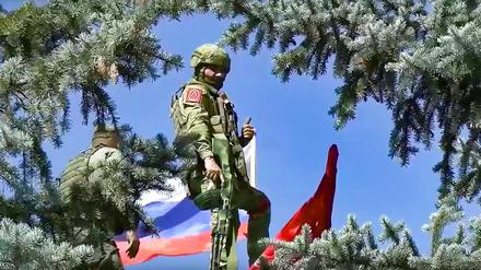 Das vom Pressedienst des russischen Verteidigungsministeriums veröffentlichte Bild zeigt zwei Soldaten, die eine russische Nationalflagge und eine Nachbildung der Siegesfahne auf das Dach des Verwaltungsgebäudes in Bilohoriwka anbringen.