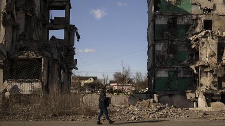 Ein Mann geht an einem Wohnblock vorbei, dessen Mittelteil nach einem Luftangriff vor einem Jahr fehlt (Symbolbild).