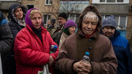 Ukrainische Frauen warten darauf, kostenloses Essen aus einer Suppenküche zu erhalten.