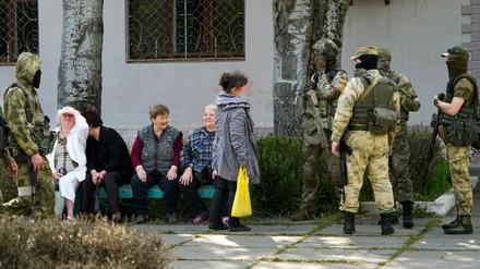 Ältere Anwohner sprechen mit einer Gruppe russischer Soldaten in Cherson am 20. Mai 2022.