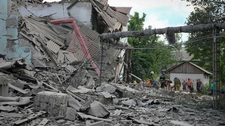 Rettungskräfte und Anwohner nach einem russischen Luftangriff auf Lyssytschansk an den Trümmern eines Gebäudes. 