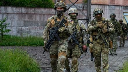Russische Soldaten gehen durch einen zerstörten Bereich des Stahlwerks Mariupol.