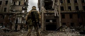 Ein ukrainischer Soldat steht vor einem zerstörten Gebäude in Mykolajiw.