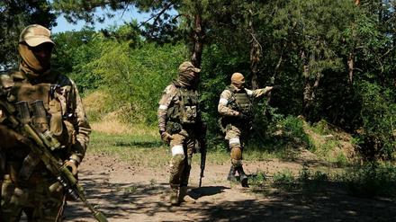 Russische Soldaten gehen an einem eroberten ukrainischen Kontrollpunkt entlang in der Nähe der Stadt Schtschastja.