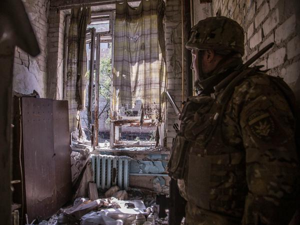 Ein ukrainischer Soldat in einem schwer beschädigten Haus in Sjewjerodonezk am 8. Juni 2022. Auch hier kämpften ausländische Soldaten mit.