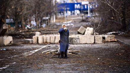 Keine demokratischen Wahlen möglich. Eine Frau sammelt am Montag in der Nähe des Donezker Flughafen Brennnholz.