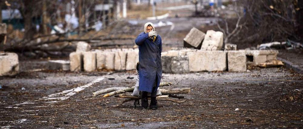 Keine demokratischen Wahlen möglich. Eine Frau sammelt am Montag in der Nähe des Donezker Flughafen Brennnholz.