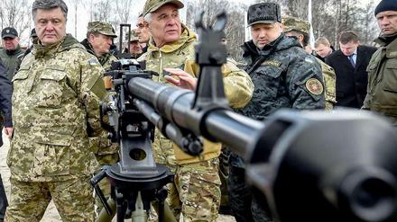 Die Waffenruhe in der Ukraine ist brüchig. Am Wochenende starben bei drei Vorfällen neun Soldaten. Präsident Petro Poroschenko (links) inspizierte am Samstag in Uniform Waffen der Nationalgarde.
