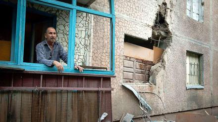 Ein Mann in Slowjansk in der Ost-Ukraine blickt nach einem Bombardement aus seinem Haus, um den Schaden zu begutachten.