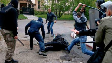 Prorussische Separatisten verprügeln in der Ostukraine einen Anhänger der Regierung in Kiew. 