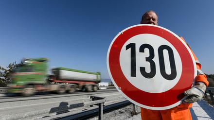 Ein Straßenwärter hält, hier an der Autobahn A81, ein Schild mit der Aufschrift "130" in den Händen.