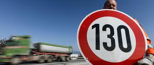 Ein Straßenwärter hält, hier an der Autobahn A81, ein Schild mit der Aufschrift "130" in den Händen.