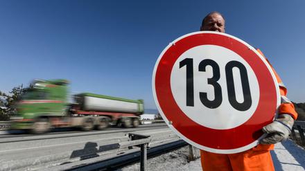 Straßenwärter hält ein Schild mit der Aufschrift „130“ in den Händen (Symbolbild). 