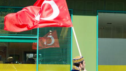 Ein Mann in osmanischer Tracht trägt in Hannover bei einem Umzug eine türkische Fahne. Die Türken wollen ohne Visa in die EU reisen - doch es gibt Hindernisse.