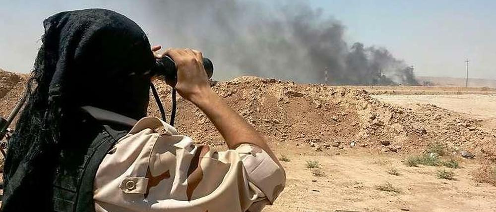 Ein kurdischer Peshmerga-Kämpfer beobachtet aus der Ferne Auseinandersetzungen mit Dschihadisten des "Islamischen Staates" nordöstlich von Bagdad.