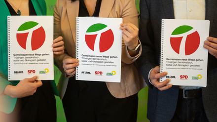 Die neue Thüringer Koalition zeigt nach der Unterzeichnung den gemeinsamen Regierungsvertrag. 