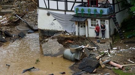 Zwei Frauen stehen neben Trümmern vor einem Haus in dem Ort im Kreis Ahrweiler am Tag nach dem Unwetter mit Hochwasser.