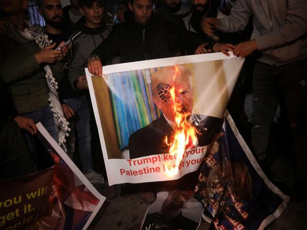 Palästinensische Demonstranten verbrennen in Betlehem ein Plakat, das US-Präsident Trump zeigt. 