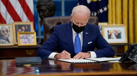 Joe Biden unterzeichnet eine Executive Order zur Einwanderung im Oval Office des Weißen Hauses.