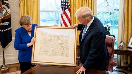 Gastgeschenk: Bundeskanzlerin Angela Merkel überreicht US-Präsident Donald Trump eine historische Karte von Rheinland-Pfalz. Von dort wanderte sein Großvater in die USA aus.