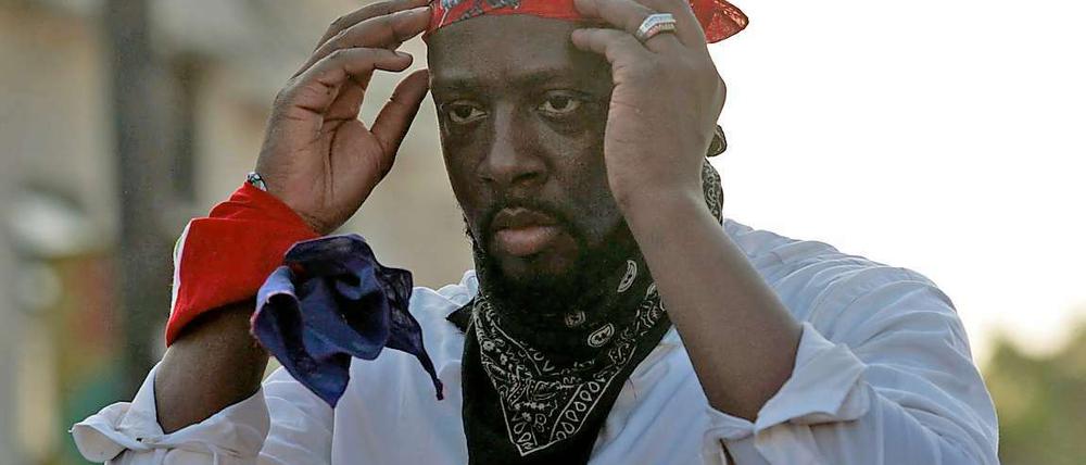 Rapper Wyclef Jean mit Kopftuch und Krawatte.