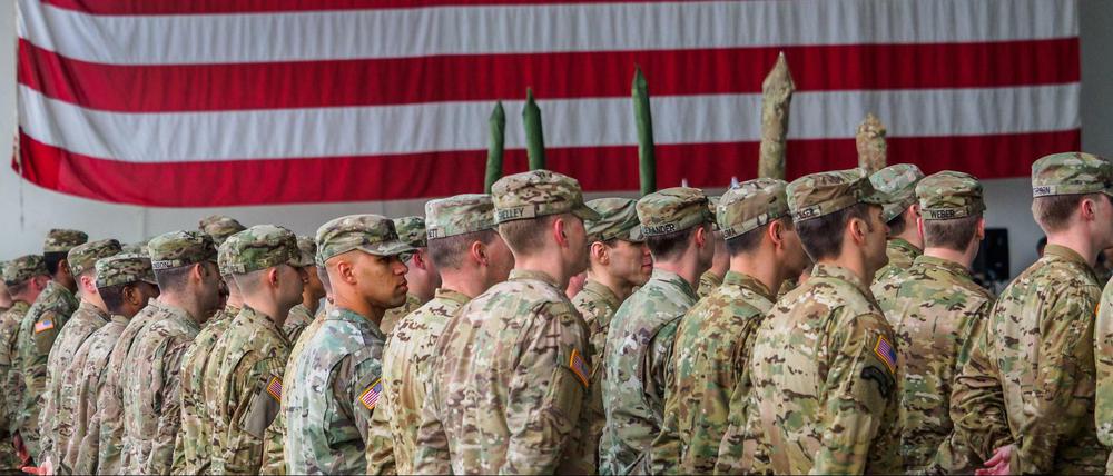 US-Soldaten stehen während einer militärischen Zeremonie vor einer US-Flagge.