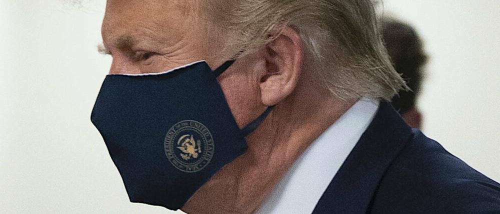 Donald Trump trägt eine Maske mit dem Siegel des US-Präsidenten.