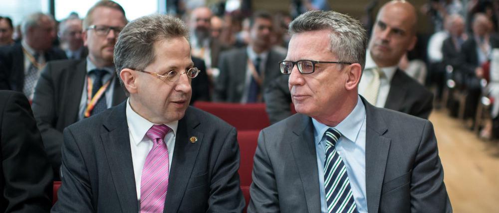 Bundesinnenminister Thomas de Maizière (r, CDU) und Hans-Georg Maaßen, Präsident des Bundesamts für Verfassungsschutz, sitzen am Montag bei einem Symposium des Bundesamts für Verfassungsschutz.