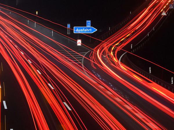 Die Langzeitbelichtung zeigt Leuchtspuren von PKW und LKW auf der Autobahn A2 an der Ausfahrt Lehrte. 
